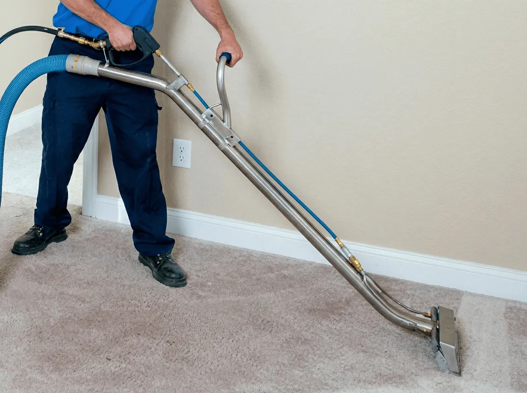 Professional operating a liquid removal machine on a carpeted floor in Henderson, NV