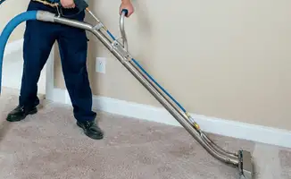 Professional operating a liquid removal machine on a carpeted floor in Henderson, NV